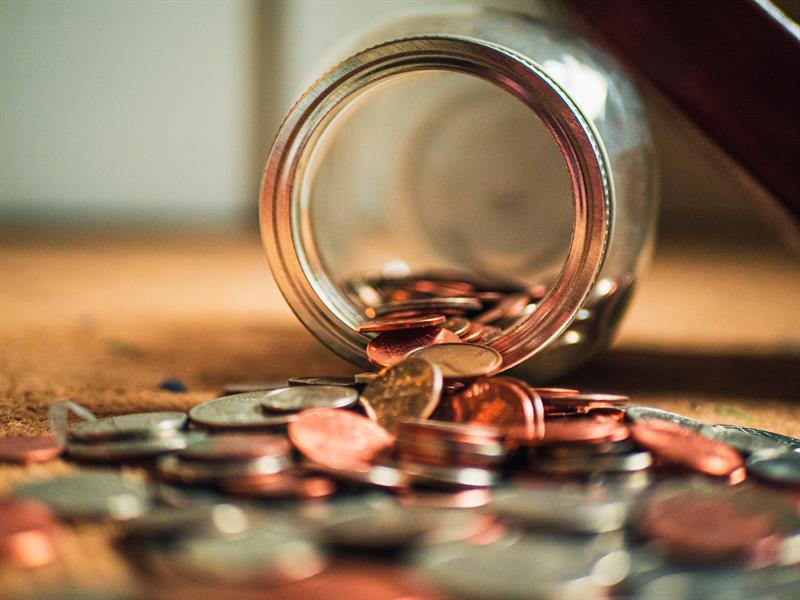 Four Habits of Smart Spending & Saving Jar of Coins Spilling on Table