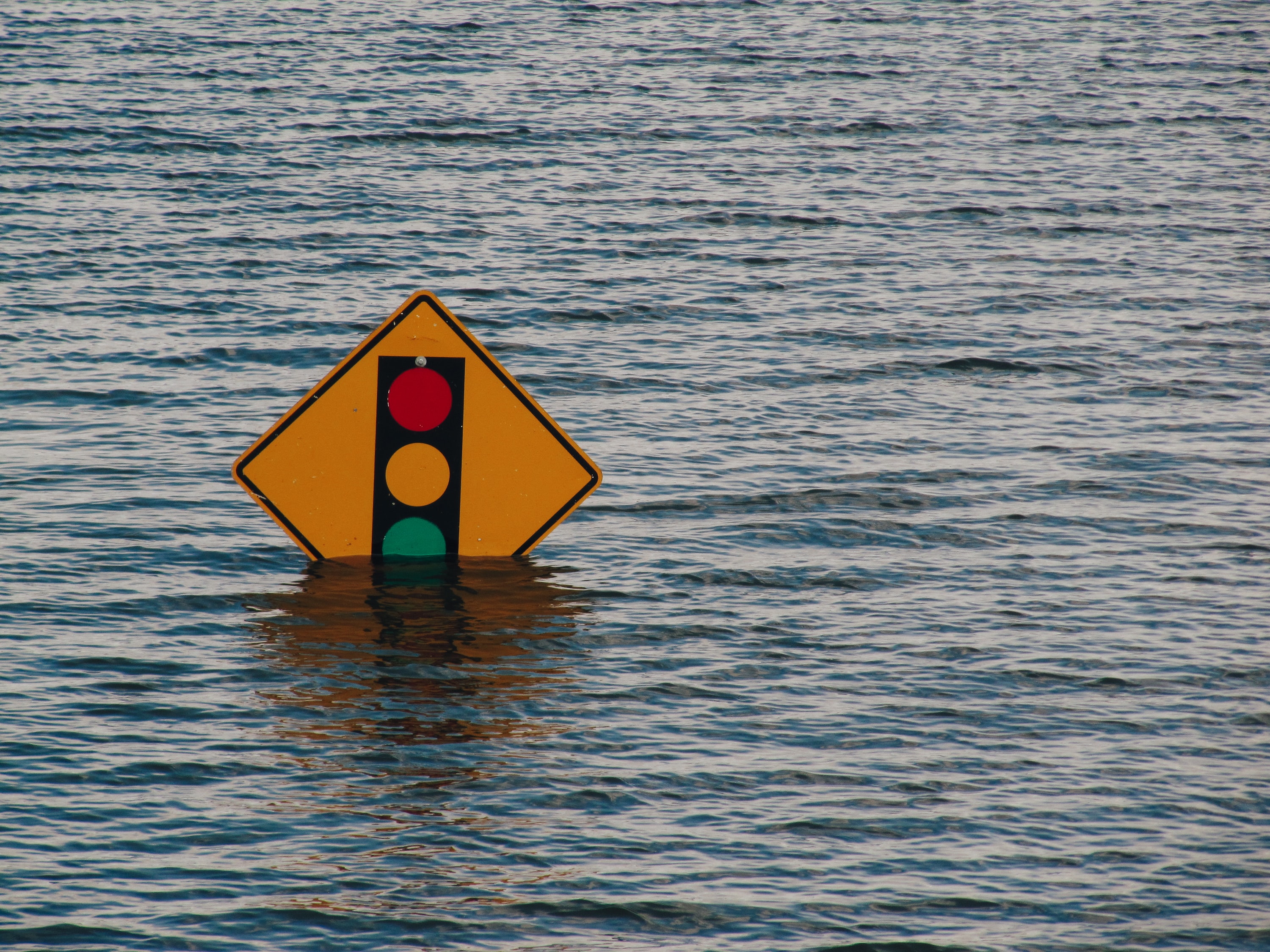 Yellow Road Sign Half Submerged in Floodwater