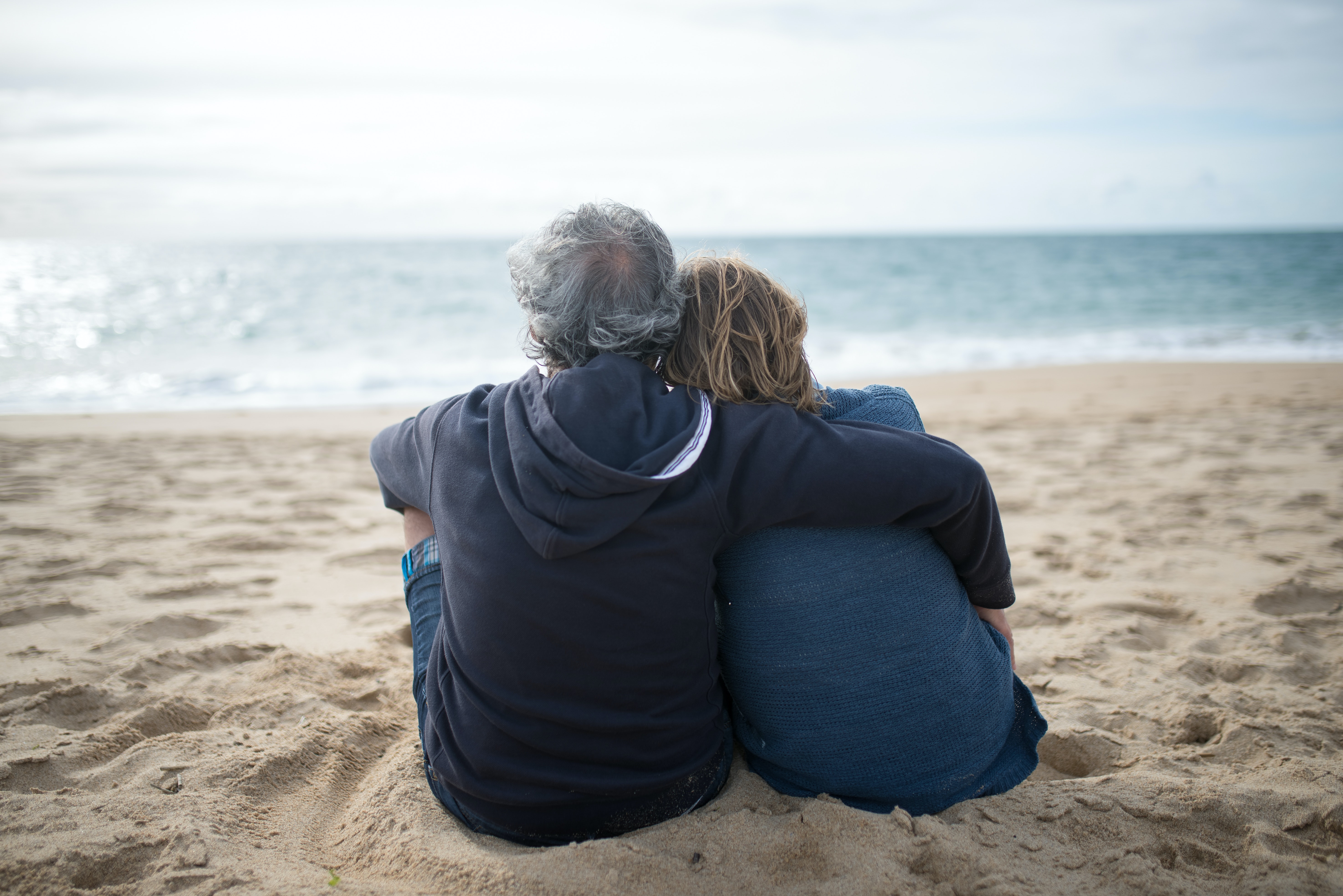 Elderly Couple Sitting on Beach