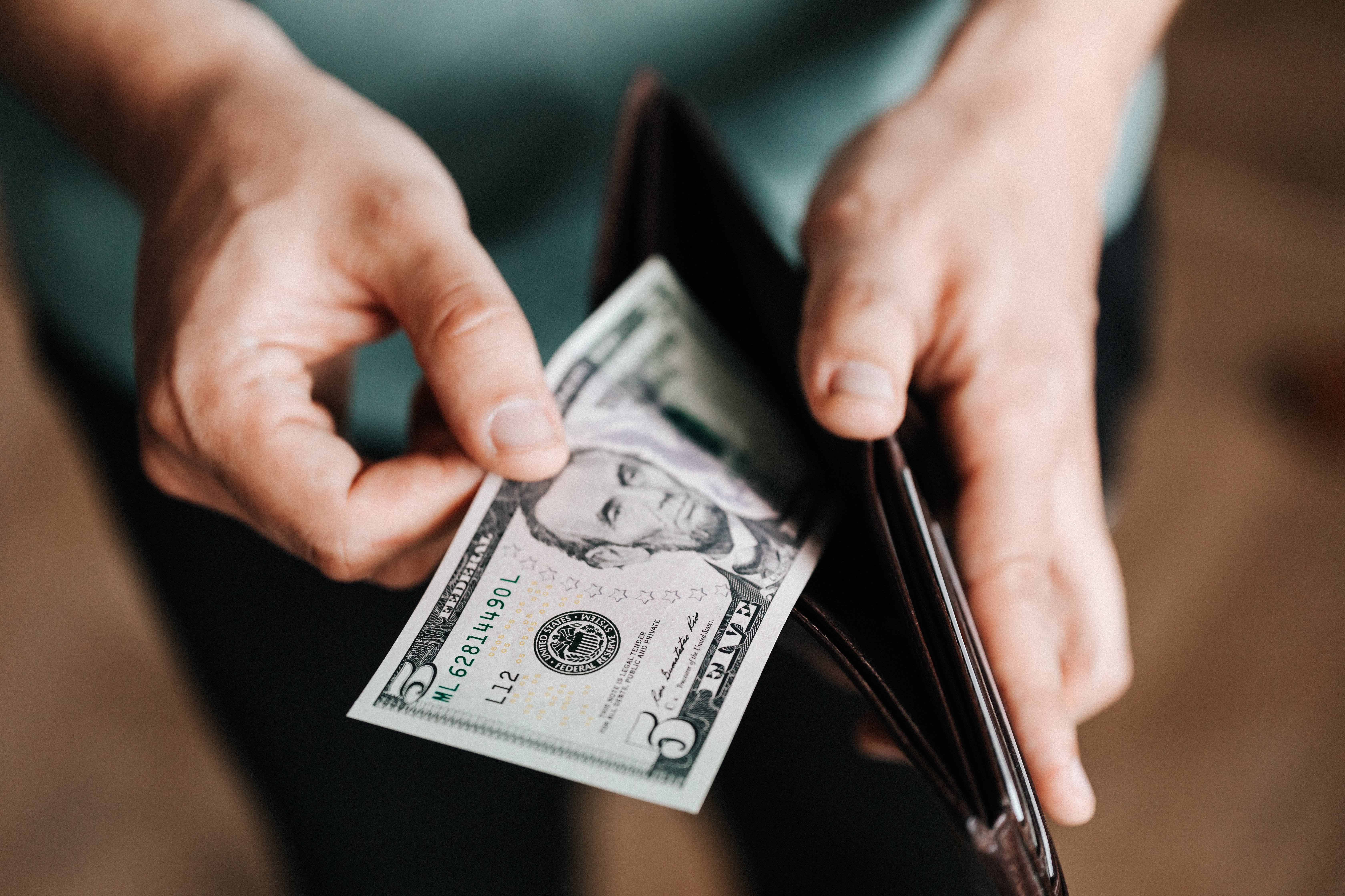 Man Pulling a Five Dollar Bill Out of Wallet