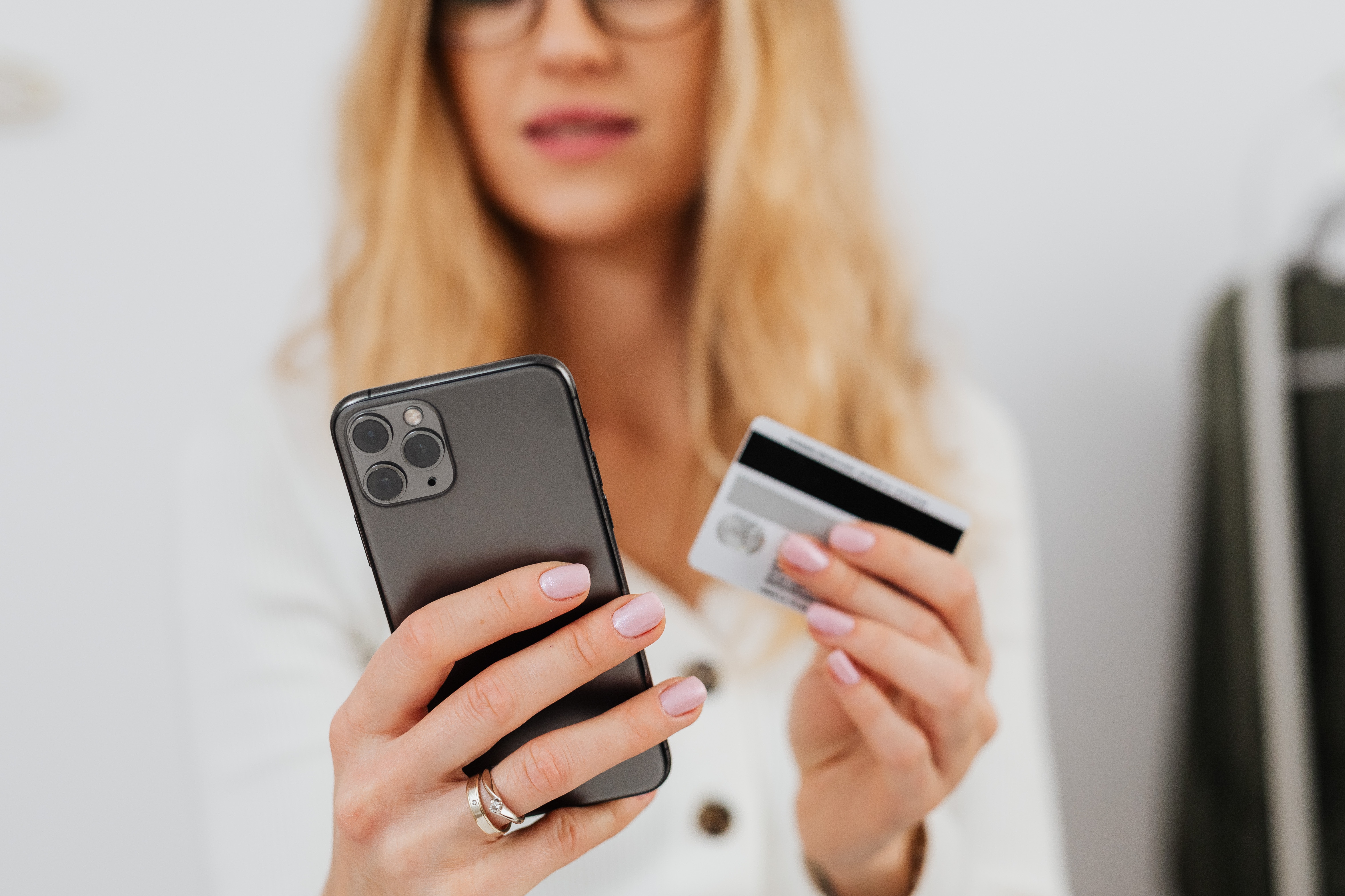 Woman Holding Phone and Debit/Credit Card