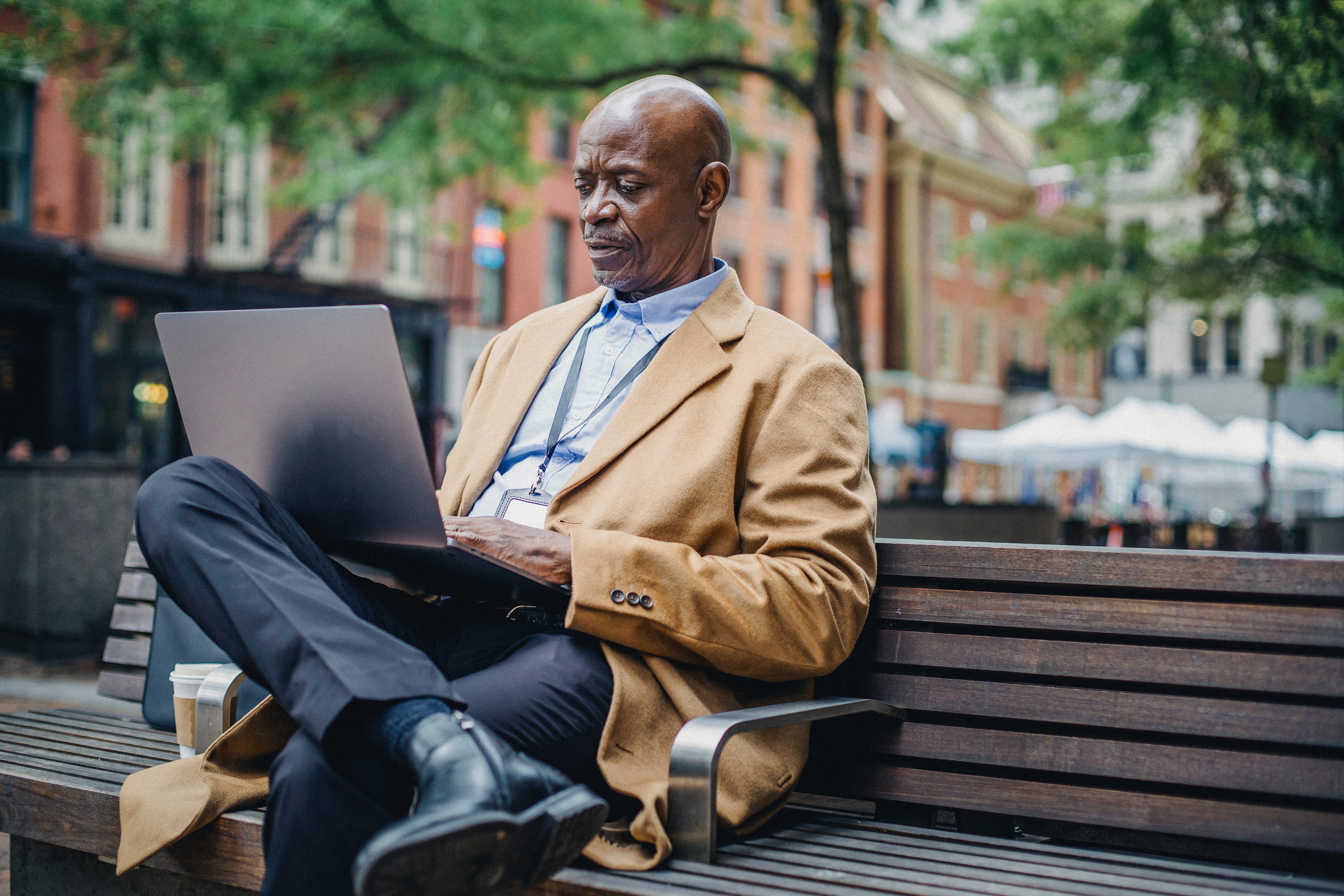 Man Sitting On Park Bench with Laptop