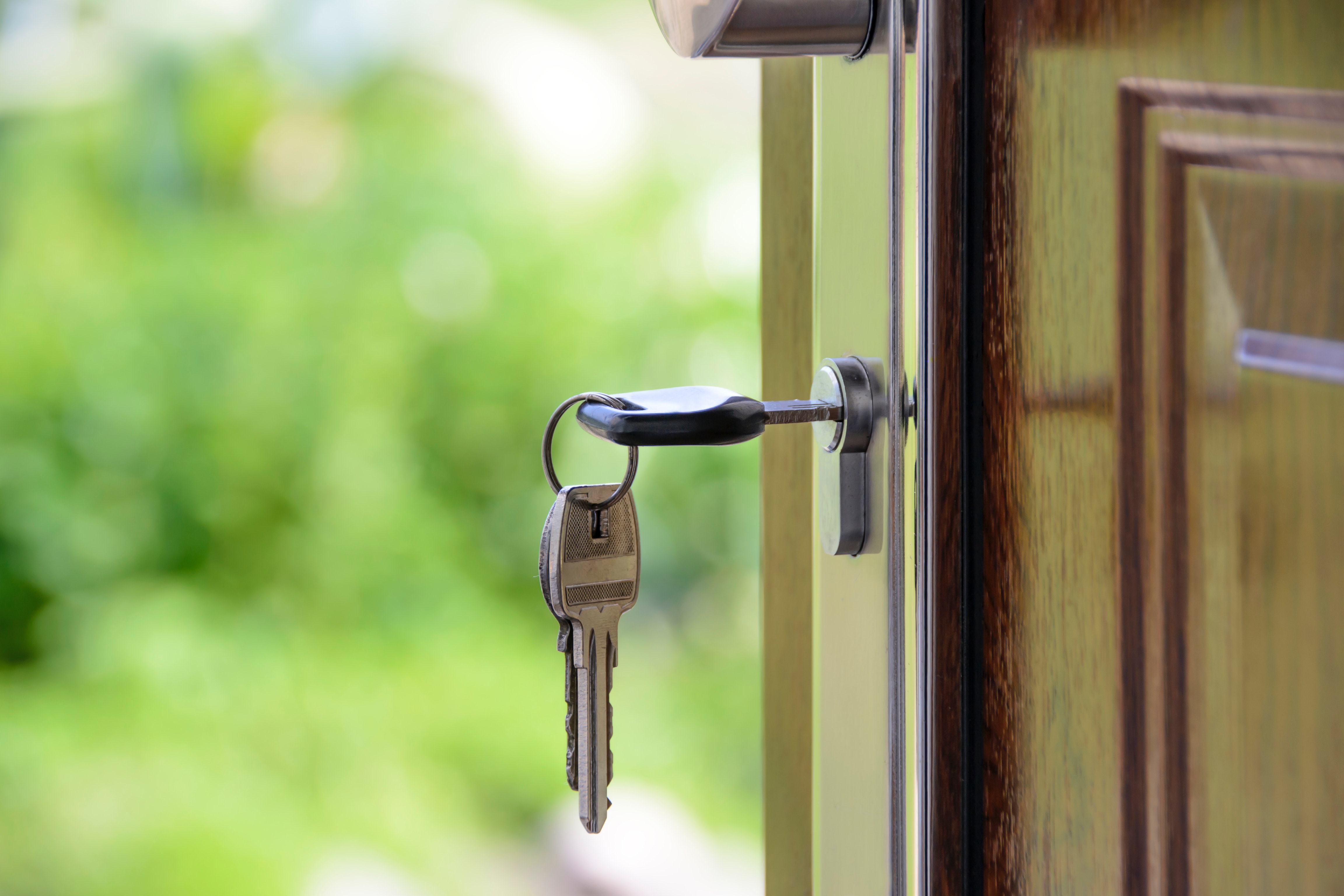 House Keys in Key Hole in Brown Door