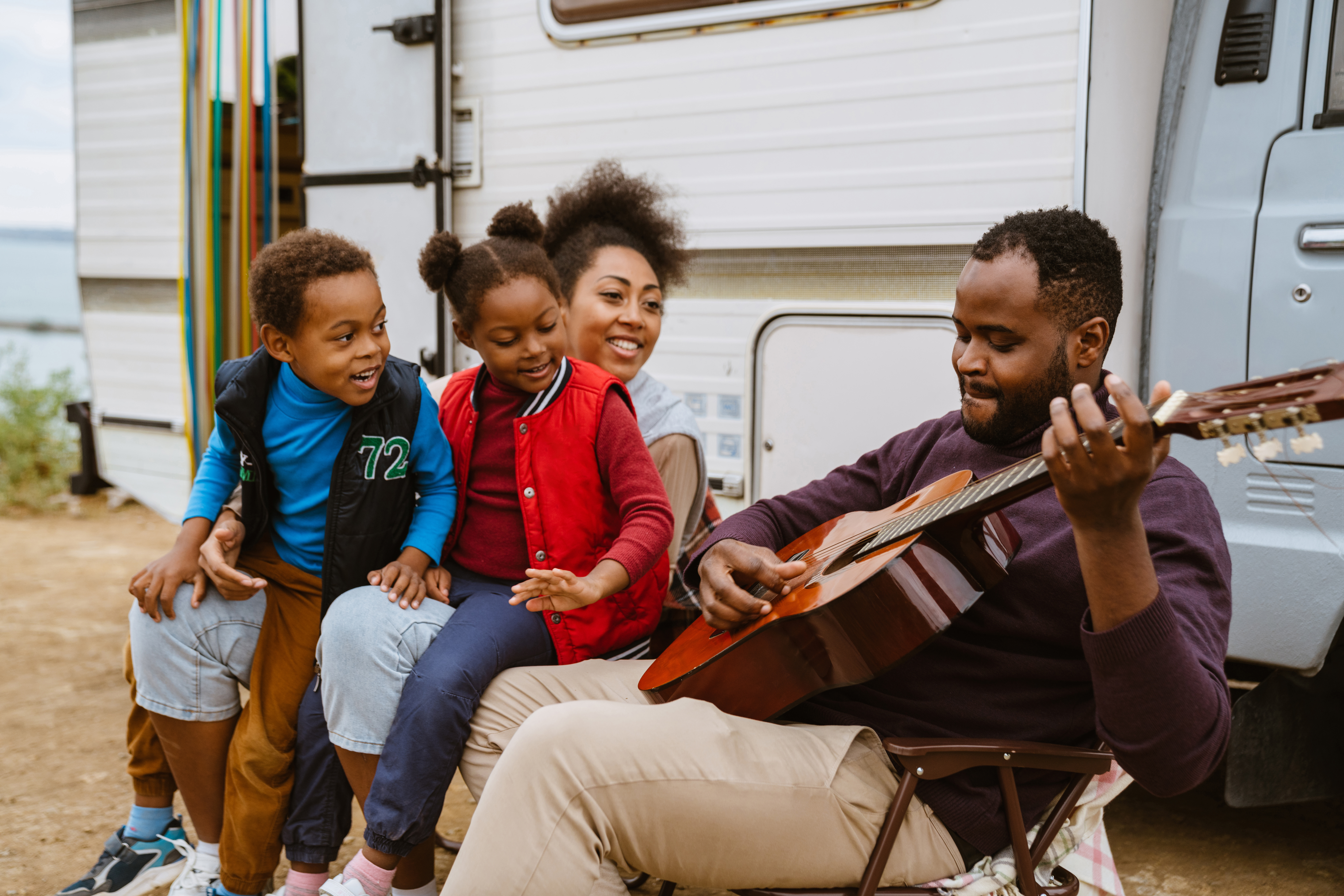 Family Outside of Camper Playing Guitar
