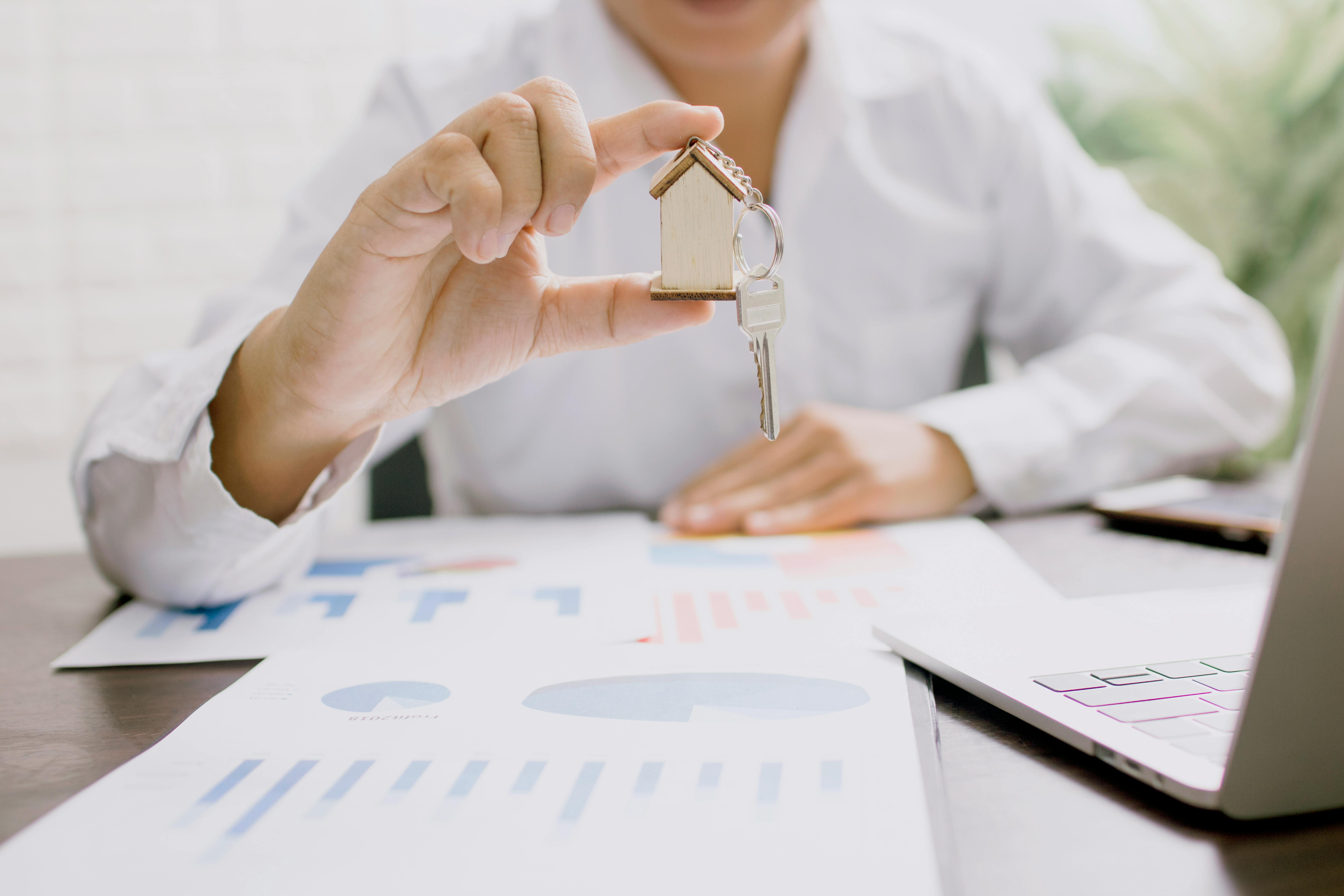 Charts with Man Holding House Keychain