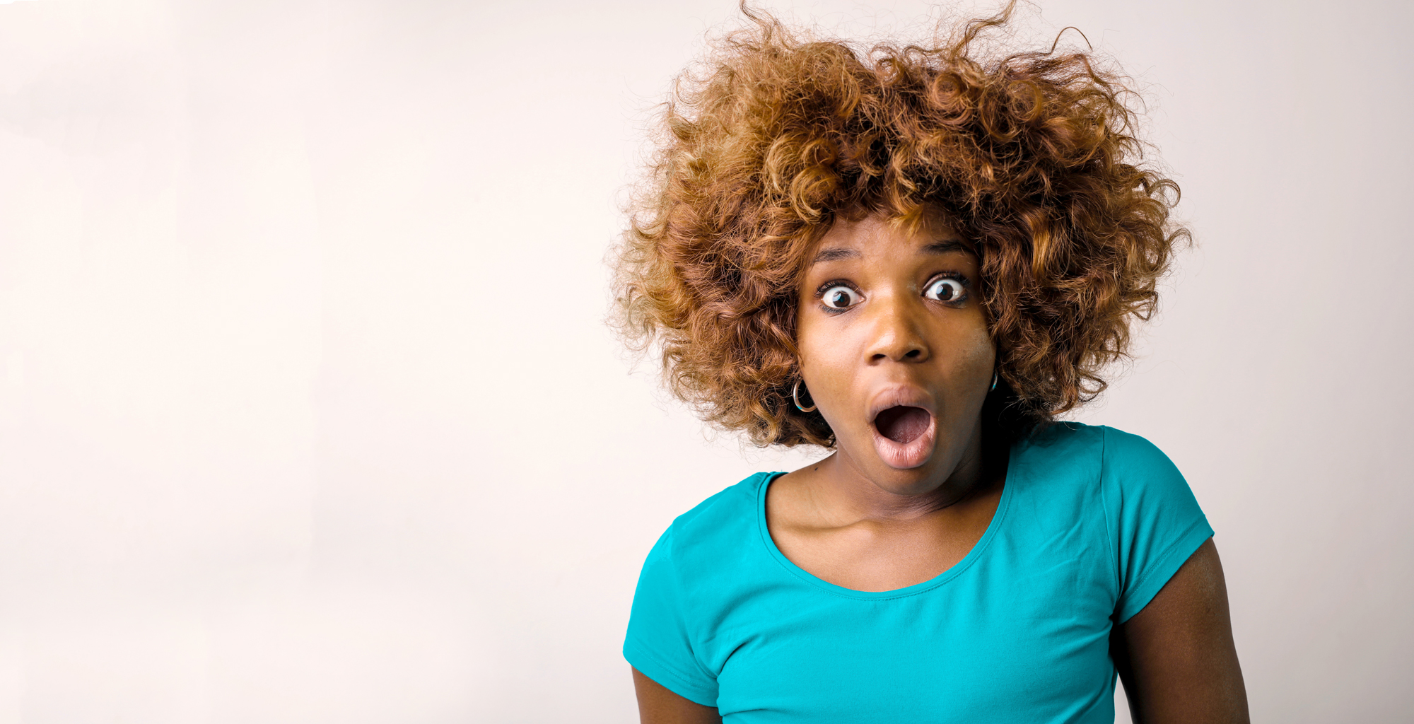 Woman in Teal Shirt with Surprised Face